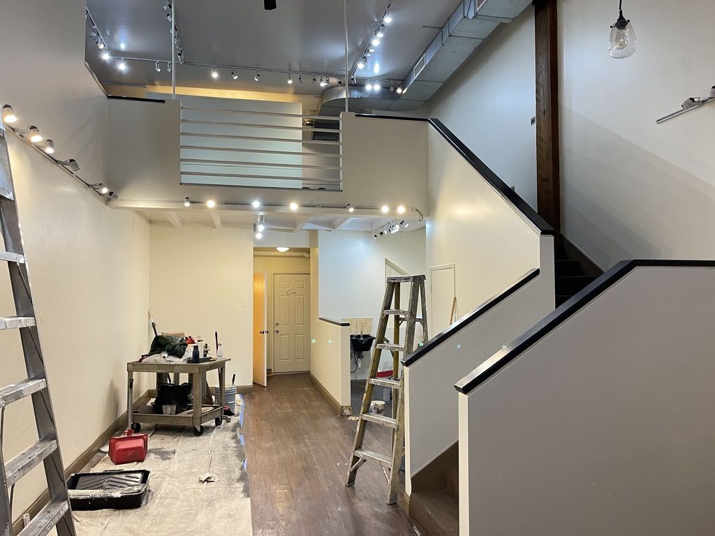 Interior repaint in progress — ladders and drop cloths in a pre-listing home