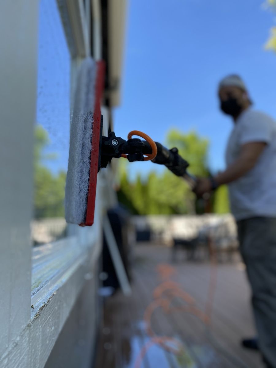 Fuego crew member cleaning exterior window glass before a listing shoot